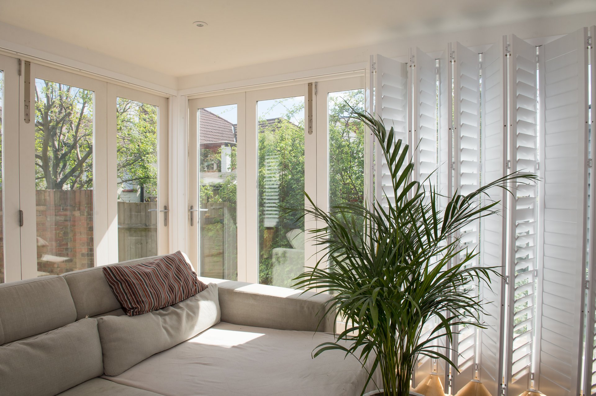 White plantation shutters in a bright garden-facing Ipswich living room